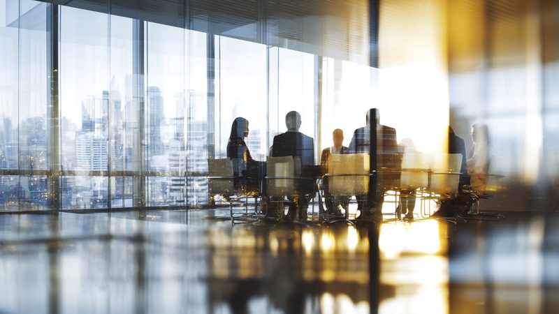 Silhouettes of people meeting in a glass-walled office, representing Professional Negligence at KMT Solicitors