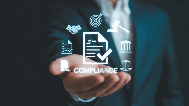 Hand holding compliance icons, representing Sponsor Compliance at KMT Solicitors