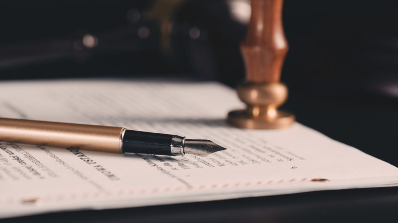Fountain pen and wax seal stamp on a legal document, representing Cross-Border Estates at KMT Solicitors
