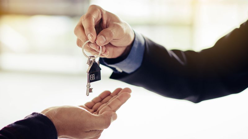 House keys handed from one person to another, representing Leases and Landlord–Tenant at KMT Solicitors