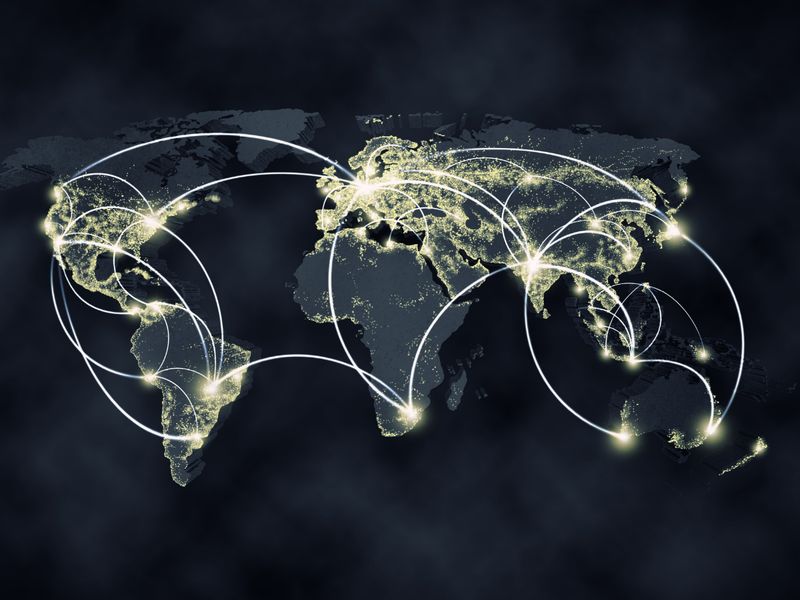Illuminated world map with connecting routes, representing the international work of KMT Solicitors