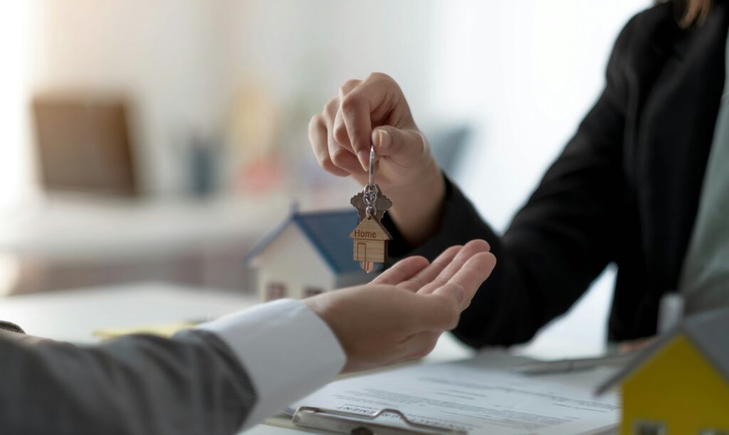 Close up hand of home,apartment agent or realtor was holding the key to the new landlord,tenant or